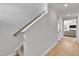 Well-lit hallway with hardwood floors, and white trim, leading to stairs and other rooms at 90 Rigsby Ave, Four Oaks, NC 27524
