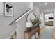 Inviting hallway features a wooden console table, round mirror, and stylish runner leading to the living room at 90 Rigsby Ave, Four Oaks, NC 27524