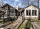 View of the backyard with wooden steps, brick foundation and screened-in porch at 916 Belhaven Rd, Cary, NC 27513