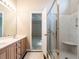Bathroom showcasing a double sink vanity, glass shower, and doorway leading to another room at 916 Belhaven Rd, Cary, NC 27513