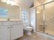 Inviting bathroom features large, tiled shower, crisp white cabinets, and decorative window at 916 Belhaven Rd, Cary, NC 27513