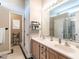 Bright bathroom featuring double sinks, a vanity with neutral wood finish, and a large mirror reflecting the shower at 916 Belhaven Rd, Cary, NC 27513