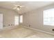 Neutral bedroom featuring a vaulted ceiling, ceiling fan, door to exterior, and 2 windows at 916 Belhaven Rd, Cary, NC 27513