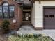 Close-up of entryway with a brick facade, front door, and fresh flowerbed at 916 Belhaven Rd, Cary, NC 27513