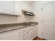 Kitchenette featuring crisp white cabinets, laminate countertop, and a convenient sink at 916 Belhaven Rd, Cary, NC 27513