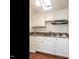 Close-up shot of the upstairs kitchenette featuring crisp white cabinets and skylight at 916 Belhaven Rd, Cary, NC 27513