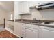 Kitchenette featuring crisp white cabinets, laminate countertop, and a convenient sink at 916 Belhaven Rd, Cary, NC 27513