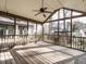 Spacious screened-in porch featuring wood floors, ceiling fan, and natural light at 916 Belhaven Rd, Cary, NC 27513