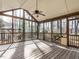 Relaxing screened porch with wood floors, ceiling fan, and views of the surrounding trees at 916 Belhaven Rd, Cary, NC 27513