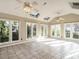 Bright sunroom featuring tile flooring, skylights, ceiling fans and windows with backyard views at 916 Belhaven Rd, Cary, NC 27513