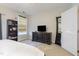 Bright bedroom with black dresser, TV, mirror and a window, offering a cozy and functional space at 9211 Calabria Dr # 117, Raleigh, NC 27617