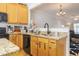 Well-equipped kitchen featuring granite countertops, wood cabinetry, and black appliances at 9211 Calabria Dr # 117, Raleigh, NC 27617