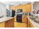 Spacious kitchen with ample counter space, wooden cabinets, and modern black appliances at 9211 Calabria Dr # 117, Raleigh, NC 27617