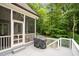 View of the back deck with a grill overlooking a beautiful wooded landscape and access to a screened-in porch at 946 Berry Patch Ln, Pittsboro, NC 27312