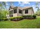 Back exterior of home with green lawn, screened-in porch, and well-maintained shrubs at 946 Berry Patch Ln, Pittsboro, NC 27312