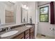 Bathroom featuring granite countertops, dual sinks, decorative mirrors, and a window for natural light at 946 Berry Patch Ln, Pittsboro, NC 27312
