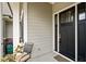 Front door with black trim, a chair on the front porch, and gray siding at 946 Berry Patch Ln, Pittsboro, NC 27312