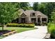 Home exterior with stone accents, well-manicured lawn, and driveway at 946 Berry Patch Ln, Pittsboro, NC 27312