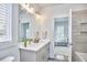 Bright bathroom featuring a double vanity with a gray cabinet, quartz countertop, and modern fixtures at 1012 Addison Pl, Raleigh, NC 27610