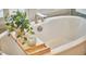 Close up of bright bathroom with white soaking tub, plantation shutters and decorative floral wall paper at 1012 Addison Pl, Raleigh, NC 27610