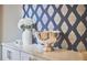 Stylish buffet with white cabinets, countertop and blue patterned wall covering, a statement piece for elegant entertaining at 1012 Addison Pl, Raleigh, NC 27610