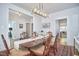 Elegant dining room with hardwood floors, a wooden table, a modern light fixture, and white trim at 1012 Addison Pl, Raleigh, NC 27610