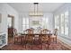 Elegant dining room with hardwood floors, a wooden table, a modern light fixture, and white trim at 1012 Addison Pl, Raleigh, NC 27610