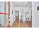 Bright foyer with hardwood floors, a red front door, white trim, and an entry table with decorative rug at 1012 Addison Pl, Raleigh, NC 27610