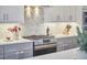 The kitchen features stainless steel appliances, light gray cabinetry, and a hexagon backsplash at 1012 Addison Pl, Raleigh, NC 27610
