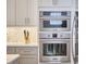 A kitchen featuring stainless steel appliances, light gray cabinetry, and a hexagon backsplash at 1012 Addison Pl, Raleigh, NC 27610