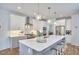 Modern kitchen with a large island, white cabinets, stainless steel appliances, and pendant lighting at 1012 Addison Pl, Raleigh, NC 27610