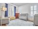Comfortable Bedroom featuring a glider chair, blue curtains, a crib, and ample natural light at 1016 Addison Pl, Raleigh, NC 27610