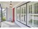 Inviting front porch featuring a red door, stylish lighting and large windows with white shutters at 1016 Addison Pl, Raleigh, NC 27610