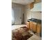 Outdated kitchen featuring wood cabinets, laminate counters, and damaged floor covering at 1117 S Blount St, Raleigh, NC 27601