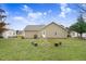 Backyard of home features a fire pit with surrounding bench seating, open lawn, and mature shade trees at 112 E Main St, Micro, NC 27555