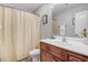 This bathroom features a vanity, a toilet, and a bathtub with a shower curtain at 112 E Main St, Micro, NC 27555