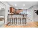 Modern kitchen with stainless steel appliances, wooden cabinets, bar seating, and hardwood flooring at 112 E Main St, Micro, NC 27555