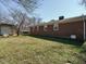A fenced backyard featuring an exterior view of the brick home and a detached storage shed at 118 Park Ave, Knightdale, NC 27545