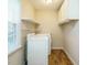 Practical laundry room with overhead cabinets and shelves for organized storage at 118 Park Ave, Knightdale, NC 27545