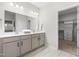 Bathroom featuring double sinks with white quartz countertop and white cabinetry, plus a view of a walk-in closet at 120 Longspur Ln, Rolesville, NC 27571