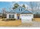 Charming single-Gathering home featuring a two-car garage, blue accents and a well-manicured lawn at 120 Longspur Ln, Rolesville, NC 27571