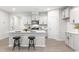 Modern open-concept kitchen featuring an island with seating, stainless steel appliances, and white cabinets at 120 Longspur Ln, Rolesville, NC 27571