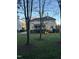 Backyard view with large lawn, patio, porch, mature trees, and privacy fencing at 12321 Penrose Trl, Raleigh, NC 27614