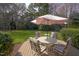 Backyard featuring patio set on deck, surrounded by trees and grass at 12321 Penrose Trl, Raleigh, NC 27614