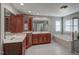 Spacious bathroom featuring dual sinks, cherry cabinets, a soaking tub and a large window at 12321 Penrose Trl, Raleigh, NC 27614