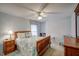 Bright bedroom with a ceiling fan, a wooden bed frame, and a blue patterned comforter at 12321 Penrose Trl, Raleigh, NC 27614