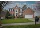 Stately two-story brick home with manicured lawn, attached two car garage, and ample curb appeal at 12321 Penrose Trl, Raleigh, NC 27614