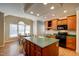 Open kitchen featuring an island, wood cabinets, and a breakfast nook with large windows at 12321 Penrose Trl, Raleigh, NC 27614