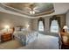 Comfortable main bedroom featuring tray ceilings, large windows, and neutral decor at 12321 Penrose Trl, Raleigh, NC 27614