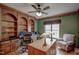 Home office with custom wooden bookshelves, ceiling fan and a desk at 12321 Penrose Trl, Raleigh, NC 27614